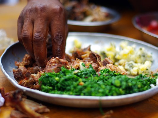 Local traditional meal of game meat, maize, and wild spinach