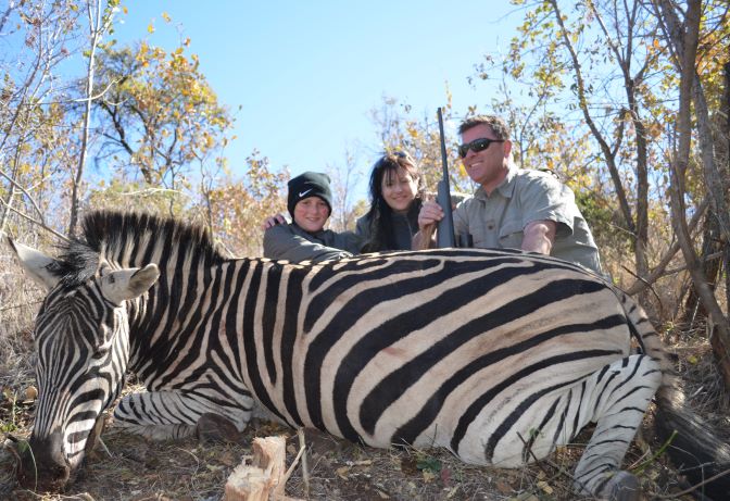 people posing with zebra they harvested.