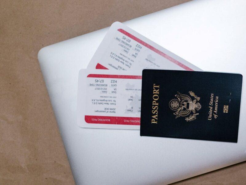 image of passport and flight tickets lying on a laptop